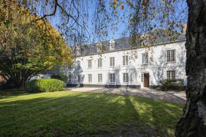 a large white house with a large yard at Le Nid des Charmettes in Saint-Josse