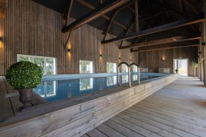 a swimming pool in a building with a wooden floor at Le Nid des Charmettes in Saint-Josse