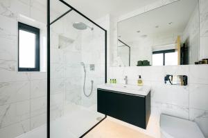 a white bathroom with a sink and a shower at Minety Lake 72 ML72 Lower Mill Estate Cotswolds in Somerford Keynes +17 photos