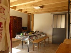 a dining room with a table and chairs and wooden ceilings at La Férandie in Chéronnac +9 photos