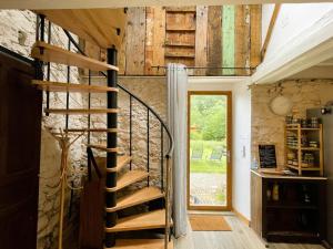 a spiral staircase in a room with a stone wall at Coume a Case - Maison de charme 4 étoiles - piscine et spa - vallée d'Ossau in Lys