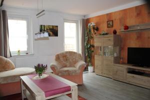 ein Wohnzimmer mit Sofa und Fernseher in der Unterkunft Ferienwohnung Edelweiß im Erzgebirge in Markersbach