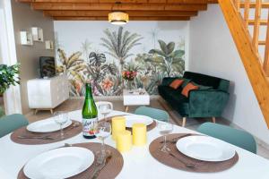a dining room with a table with plates and wine glasses at La Canopée Atypique Vendée in Luçon