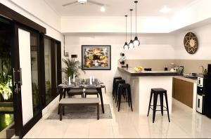 a dining room and kitchen with a table and chairs at Villa Mimoza Umalas Bali in Kerobokan