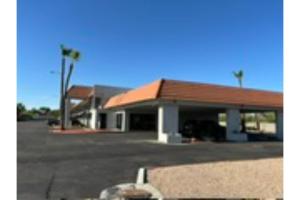 un edificio con un parcheggio e palme di Motel 6 Mesa, AZ - Downtown a Mesa