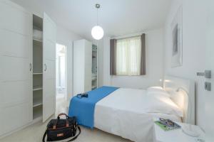 a white bedroom with a bed and a bag at Masseria Agriturismo Faresalento in Gallipoli +92 photos