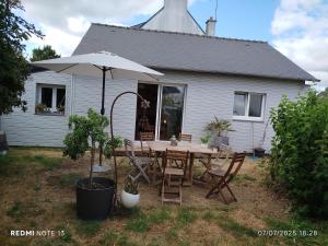 a table with an umbrella in front of a house at Lucette in Vannes