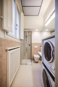 a bathroom with a toilet and a washer and dryer at Mini-loft just steps from the Duomo of Modena in Modena +14 photos