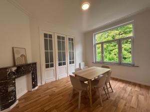 a dining room with a table and chairs and a fireplace at Leopold Brussels 6 in Brussels