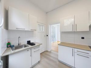a white kitchen with white cabinets and a sink at Sacre-coeur Brussels 1 in Brussels