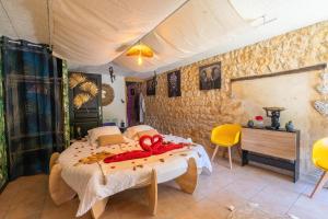 a bedroom with a bed with red towels on it at Le Vésuve avec jaccuzi in Saint-Genis-de-Saintonge