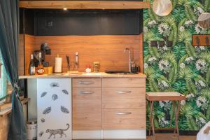 a kitchen with a sink and a refrigerator at Le Vésuve avec jaccuzi in Saint-Genis-de-Saintonge +13 photos