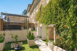 a courtyard with plants and flowers in a building at Le Vésuve avec jaccuzi in Saint-Genis-de-Saintonge