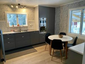 a kitchen with a table and a sink and a stove at Beloni 122 in Gustavsfors
