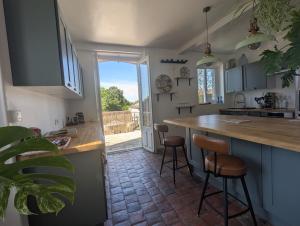 a kitchen with a counter and two bar stools at Grand Deluxe Poule Noire in Égreville