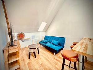 a living room with a blue couch and a table at Poule Noire Ukraine in Égreville