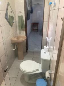 a small bathroom with a toilet and a sink at Rota Itacaré Surf Hostel in Itacaré