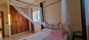 Un dormitorio con una cama con dosel y una ventana. en Martil Oasis with Private Pool, en Martil 25 fotos más