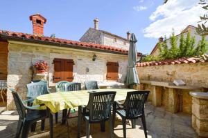 a patio with a table and chairs and an umbrella at Apartment Vinkuran 6 in Vinkuran