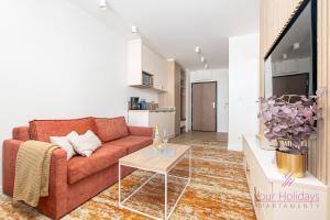 a living room with a couch and a table at Your Holidays Bel Mare Aqua F203 in Międzyzdroje +7 photos