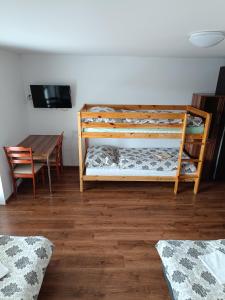 a bedroom with a bunk bed and a table at Apartmany Tatra Relax, Velky Slavkov in Vysoke Tatry - Dolny Smokovec
