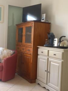 a large wooden cabinet with a tv on top of it at studio neuf climatisé in Les Fumades-Les Bains