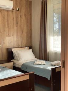 two beds in a room with a window at Mountain breeze in Lagodekhi