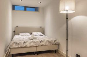 a bedroom with a bed with a lamp and a window at Charming Stay De Pijp at Centrum in Amsterdam