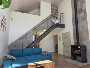 un salon avec un canapé bleu et un escalier dans l'établissement Kambarių nuoma Naujojoje Akmenėje, à Naujoji Akmenė