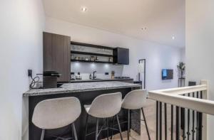 a kitchen with a bar with four stools at Charming Stay De Pijp at Centrum in Amsterdam