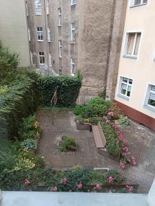 a garden with a bench and flowers in front of a building at Apartament Park&Stadion in Szczecin