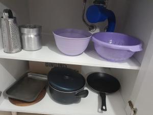 a shelf with bowls and other kitchen utensils at Monoambiente céntrico in Paraná +3 photos