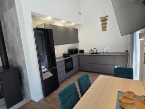 a kitchen with a wooden table and blue chairs at Kambarių nuoma Naujojoje Akmenėje in Naujoji Akmenė +19 photos