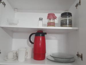 a red tea kettle is sitting in a refrigerator at Monoambiente céntrico in Paraná