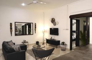 a living room with a couch and a tv at Villa Mimoza Umalas Bali in Kerobokan