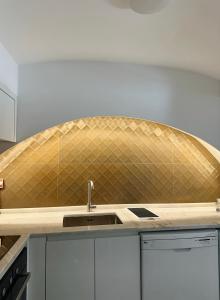 a kitchen with a sink and a tiled wall at Casas do Largo- Amor é Cego in Estremoz