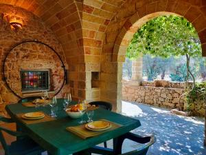 a green table with plates and wine glasses on it at Il Campanile di Casa Camilla Journey in Tiggiano