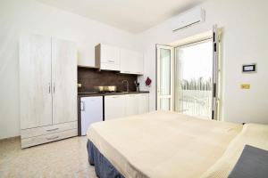 a white bedroom with a bed and a kitchen at SoleMarePonza Casa Maria in Ponza