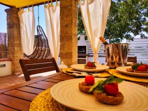 a wooden table with plates of food on top of it at La Cupola di Casa Camilla Journey in Tricase