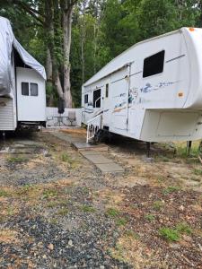 due camper bianchi parcheggiati uno accanto all'altro di Comfortable RV in a farm a Nanoose Bay