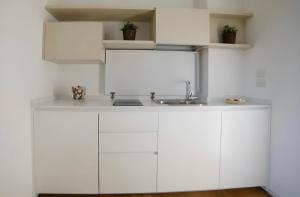 a kitchen with white cabinets and a sink at Casa Festa Rooms in Matera +74 photos