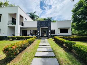 a white house with a pathway in front of it at Casa de campo in Santa Fe de Antioquia
