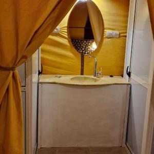 un baño con lavabo y espejo en Luxury camps merzouga, en Merzouga