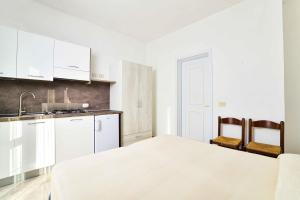 a white kitchen with a bed and a sink at SoleMarePonza Casa Maria in Ponza +35 photos