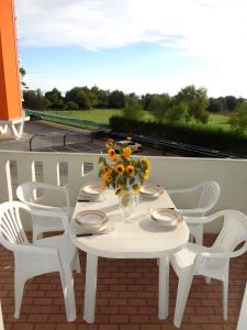 a white table with a vase of flowers on a balcony at Apartments Porto Santa Margherita 25671 in Porto Santa Margherita di Caorle
