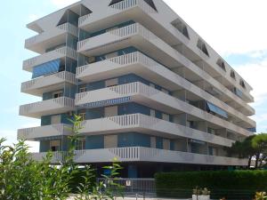 a tall apartment building with white balconies at Apartments Porto Santa Margherita 25671 in Porto Santa Margherita di Caorle