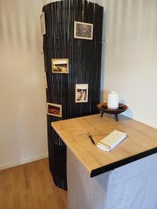 a room with a table with a candle and a wall with pictures at Parenthèse Aiyanna in Moux-en-Morvan +7 photos