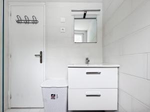 Un baño blanco con lavabo y espejo. en L'art de vivre en Baie, bel apt avec parking, en Saint-Valery-sur-Somme 22 fotos más