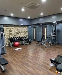 a gym with exercise equipment and a brick wall at Pines Cozy suites with balcony in Baguio