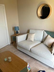 a living room with a white couch and a table at Bleu Azur -Vue Mer 6e Etage - Triangle d'Or in Saint-Raphaël +9 photos